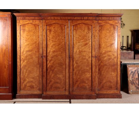 A VICTORIAN MAHOGANY BREAKFRONT TRIPLE WARDROBE the central cupboard opening to slides and deep drawers, each of the flanking