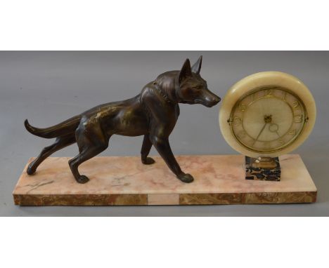 An Art Deco marble mantle clock with spelter hollowcast dog adornment set on marble base. 72cm long.