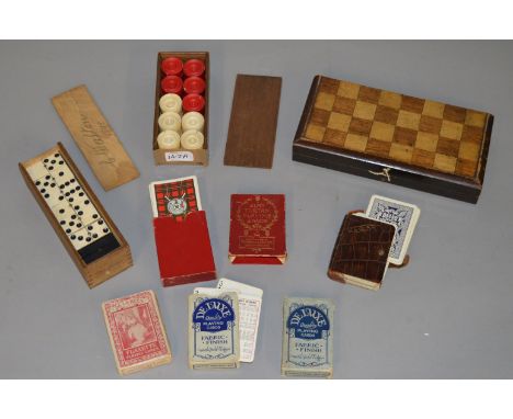 Mixed lot of vintage games including bone and ebony dominoes, stained bone draghts pieces and various playing card sets.