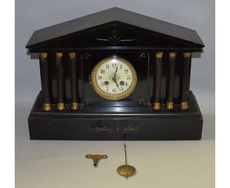 A Victorian black slate chiming mantle clock with enamel face. Movement marked 9868. With pendulum and key. 30cm tall.