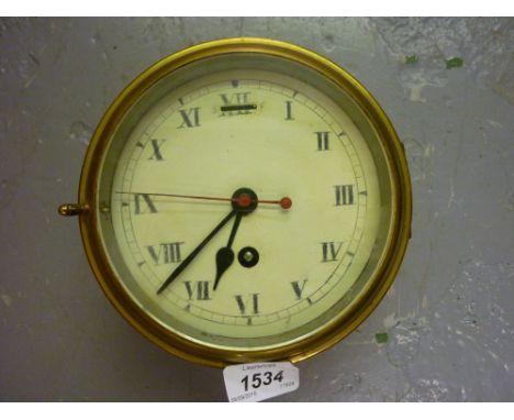 Early 20th Century ships brass cased bulk head clock with a single train key wind movement, the enamel dial with Roman numera