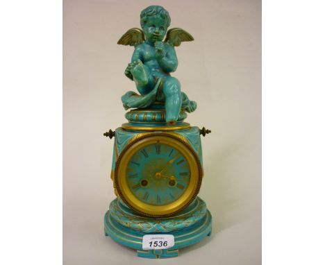 19th Century French turquoise glazed pottery mantel clock in the form of a cherub seated on a column, the circular dial with 