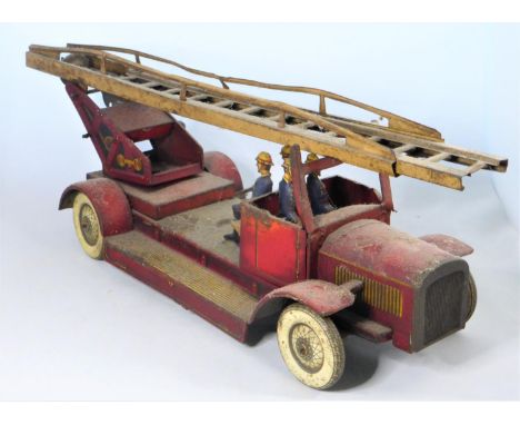 A Fire Engine with Personnel Sold in 'as found' condition, a key-wound toy with revolving and raising ladder. 38cms long.