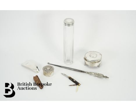 A silver shoe horn, silver trinket box, silver handled button hook, glass vanity jar and a miniature fruit knife.&nbsp;