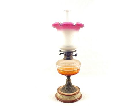 A cut glass oil lamp with pink etched shade on Royal Doulton style stoneware base