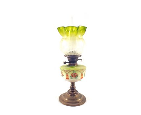 A painted green glass oil lamp with etched shade