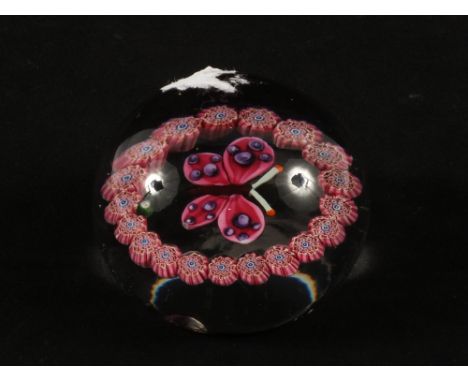 A vintage Paul Ysart glass paperweight with monogram cones and butterfly decoration (light base flaw)