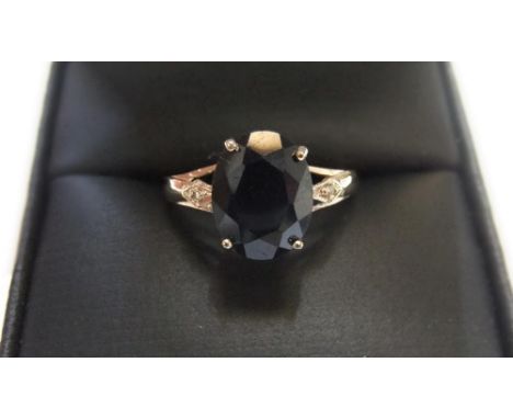 9ct yellow imported yellow gold ring set with a large black sapphire & with a small diamond set to either shoulderApprox 1.1 