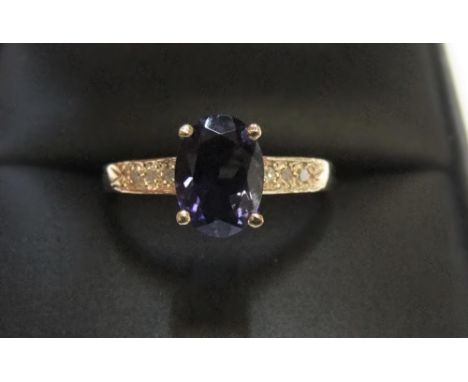 9ct yellow imported gold ring set with an oval cut iolite and with small diamonds set to the shouldersApprox 1.3 grams gross,