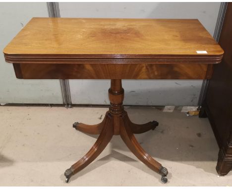 A figured mahogany fold-over card table in the Georgian style, on turned column with quatrefoil base, 86 cm 