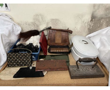 A crocodile skin handbag together with a collection of clutch bags, linen, large flat iron / door stop and an enamel pot and 