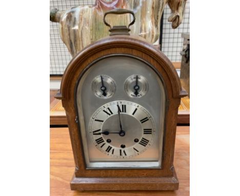 A 20th century oak cased bracket clock, with a domed top and carrying handle, the silvered dial with Roman numerals, Slow/Fas