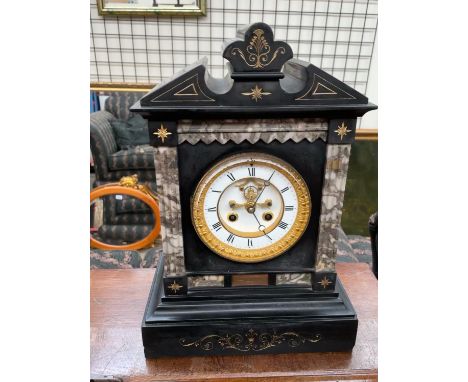 A Victorian black slate mantle clock, of architectural form, the circular dial with Roman numerals and insight movement, stri