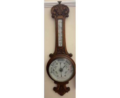An oak cased aneroid barometer, with a mercury thermometer and a ceramic dial