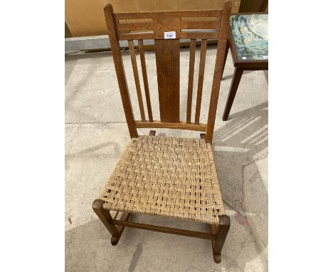 A CHILD'S OAK ROCKING CHAIR WITH WOVEN SEAT 