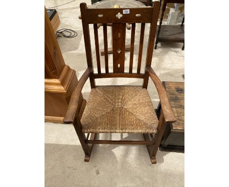 AN ARTS AND CRAFTS STYLE OAK ROCKING CHAIR WITH RUSH SEAT 