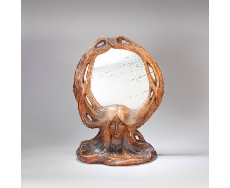 EUROPEAN; IN THE STYLE OF GOLDSCHEIDER Art Nouveau mirror, circa 1900 Terracotta with coloured finish, modelled as the head o