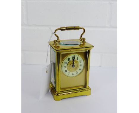 Brass cased carriage clock with enamel chapter ring showing Arabic numerals, with carry handle to top, height overall 14cm 