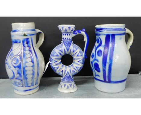 Three 19th century German Westerwald stoneware jugs to include one with a ring shaped body, tallest 24cm, (3)