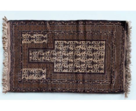 An early 20th century Afghan Baluch-style prayer mat The central Mihrab with a repeating foliate pattern on a cream ground an