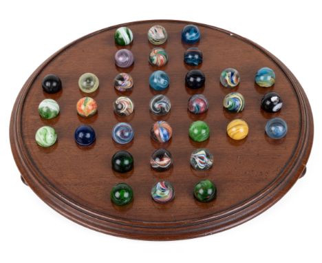 An Edwardian mahogany solitaire board Complete with Victorian and Edwardian marbles31cm diameterQty: 1In generally good condi