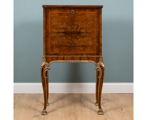 An 18th century and later walnut drinks cabinet on stand The fall-front enclosing a mirrored interior, standing on a parcel g