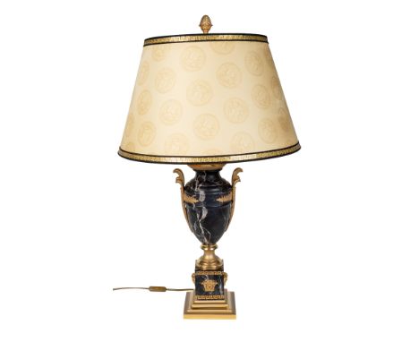 A Versace table lamp and matching shade  The turned black marble lamp with gilt mounts on a plinth with Medusa masks and a st