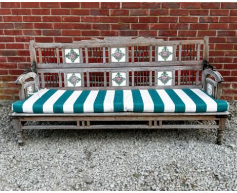 An Indian hardwood garden bench The reversible back articulating on a hinge with Art Nouveau-style ceramic tiles set within t