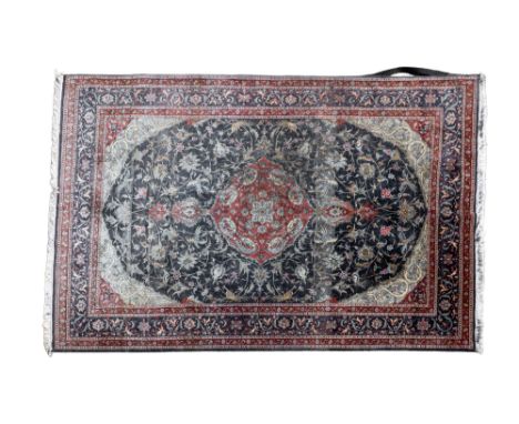 A 20th century hand woven Tabriz rug With a red central medallion with arabesque and pelmet decoration, on a dark blue ground