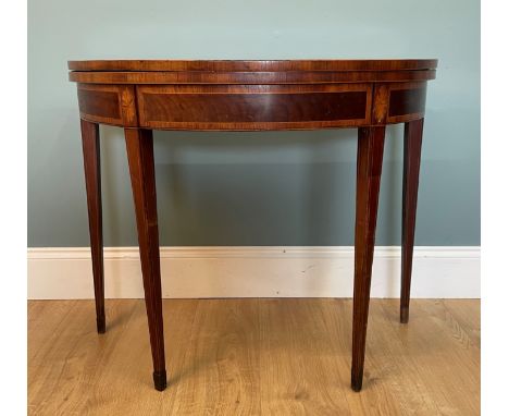 A Georgian mahogany demi-lune card table With crossbanded decoration, the top opening to reveal a green baize inset with an i