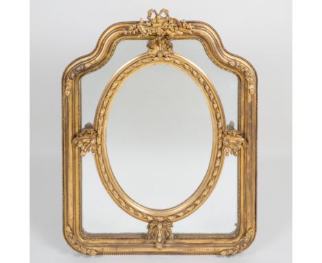 A decorative gilt wall mirror The central oval mirror plate surrounded by mirrored slips, all within a moulded frame surmount