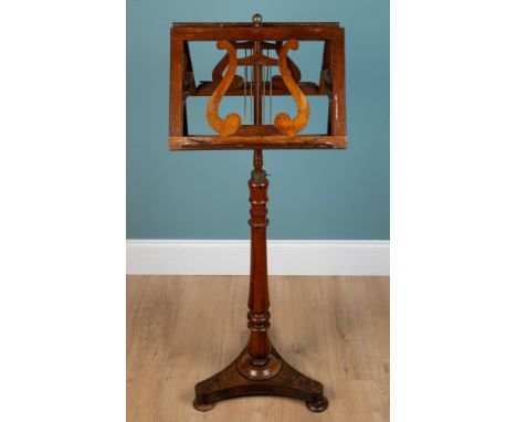 A rosewood duet music stand With a ratchet adjustable top and a retractable turned support, raised on triform base120cm highW