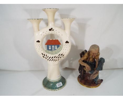 A good quality Capodimonte of an elderly gentleman sewing a sock 25 cm (h) and an unusual ceramic candelabra with pierced dec