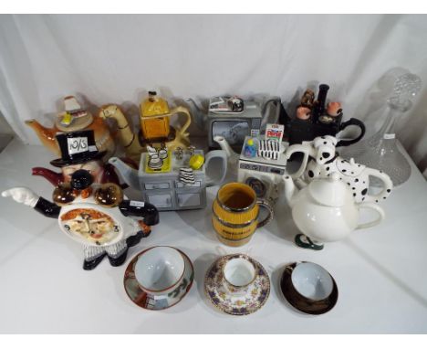 A lot to include ten novelty teapots, a ceramic Wade mug in the form of a barrel, a ship's decanter and three cups and saucer