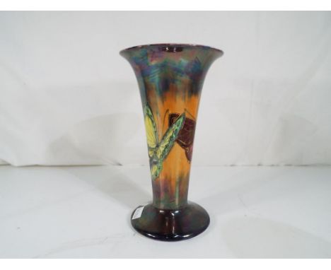 Clarice Cliff - A Wilkinson's lustre trumpet vase, decorated with iridescent colours and butterflies, approximately 21 cm (h)