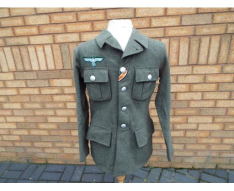 Uniform - a German WWII M44 enlisted soldiers woolen field tunic, four button front, with tunic patch and breast eagle patch,