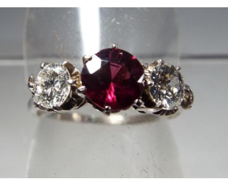 A lady's garnet and diamond three stone presumed 18ct white gold ring, approx diamond weight 0.7 of a carat set in 6 claws, s