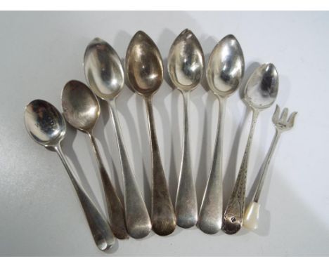 A small quantity of hallmarked silver spoons and a pickle fork with various assays, approximate weight 145 grams