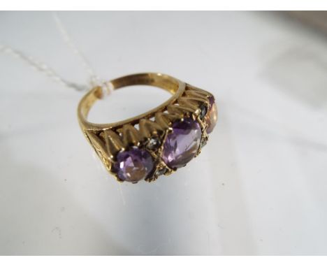 A 9 ct yellow gold 3 stone Amethyst dress ring, comprising of a central oval Amethyst 9 x 7mm, with a 7 x 5mm Amethyst either