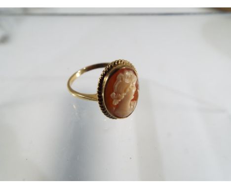 A 9ct yellow gold cameo ring, comprising of a bezel set oval cameo 15 x 11mm with twist wire surround, on a plain knife edge 