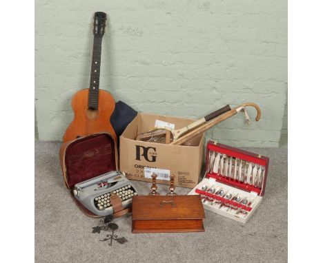 A box of miscellaneous. Includes acoustic guitar with carry case, Dunlop Pioneer racket, Royal Royalite 100 typewriter etc.