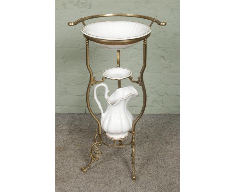 A three tier brass wash stand with gilt decorated ceramic bowl, soap dish and wash jug. Approx. height 80.5cm.