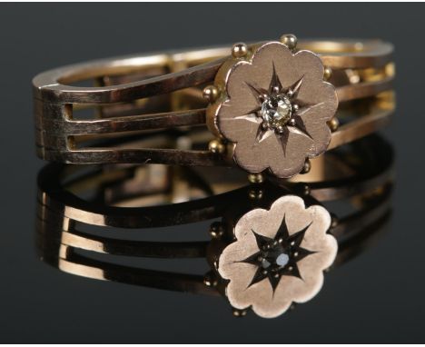 A 9ct Gold three banded scarf clip with central flower head, set with a diamond. Total weight: 4.4g.