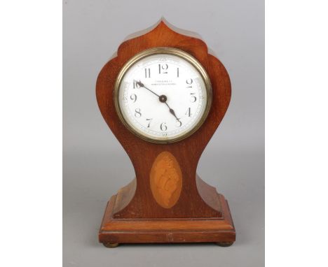 A vintage "Finnegans Ltd Manchester" mahogany cased inlaid balloon mantel clock with a clear dial featuring Arabic numerals. 