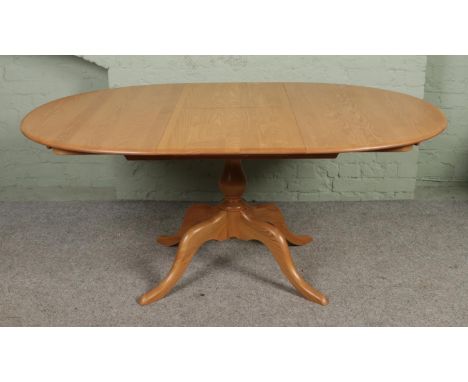 A light Ercol 'Chester' oval extending dining table, with central pillar supported by four feet. Height: 73cm, Length (extend