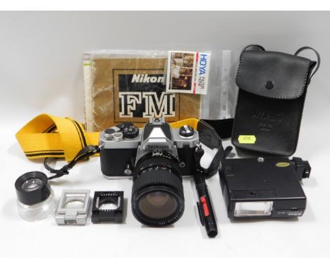 A Nikon FM 35mm film camera with 28-70mm lens &amp; manuals/accessories