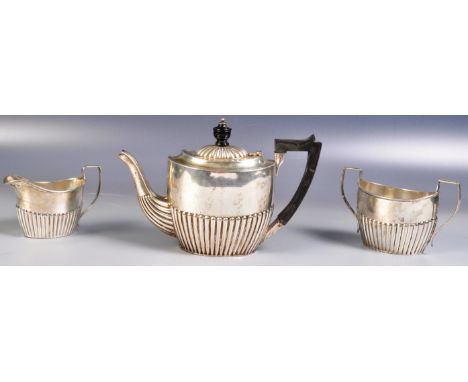 A late Victorian hallmarked silver three piece tea service comprising of a teapot with ebonised handle and finial and a hinge