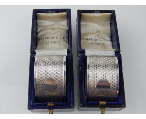 A pair of cased silver napkin rings, with engine turned decoration, Birmingham 1933. 