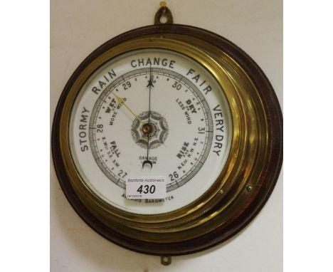An early 20th century brass and oak aneroid barometer, porcelain dial marked Gamage, London 25cm x 25cm 
