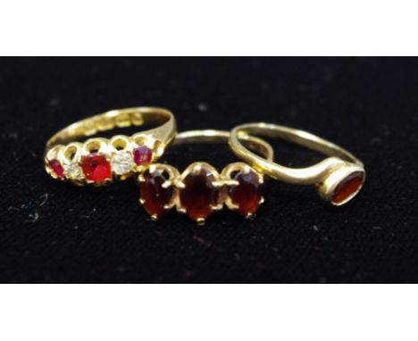 An 18ct gold, diamond and ruby ring; two garnet rings (3)